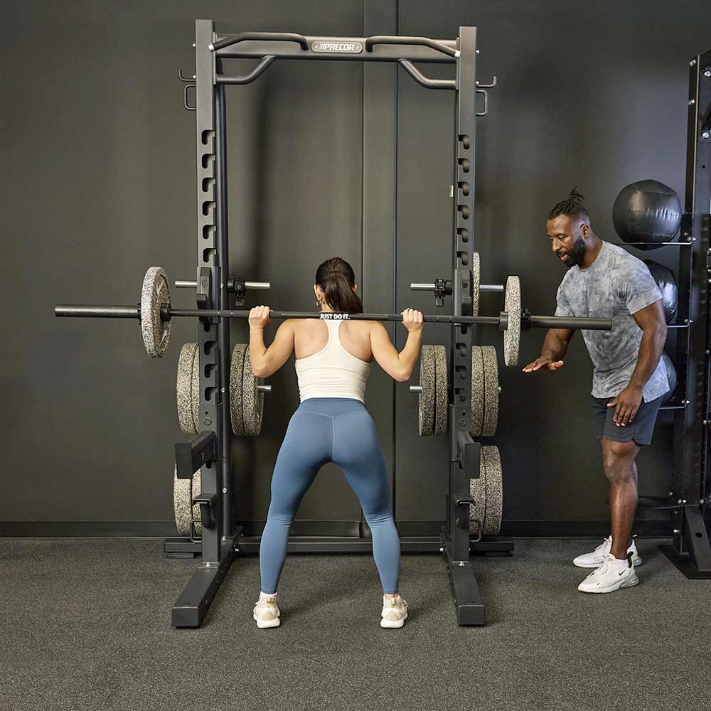 User performing barbell squats on the Precor DBR-611 Half Rack