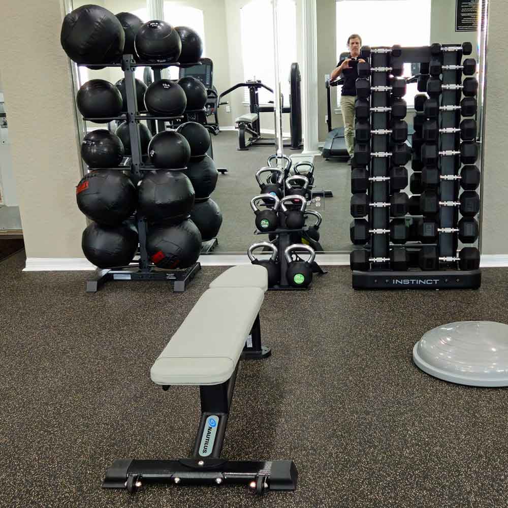 Nautilus Instinct multi-adjustable bench with kettlebells, dumbbells and medicine balls in the Andover Place apartment fitness center in Tampa, Florida