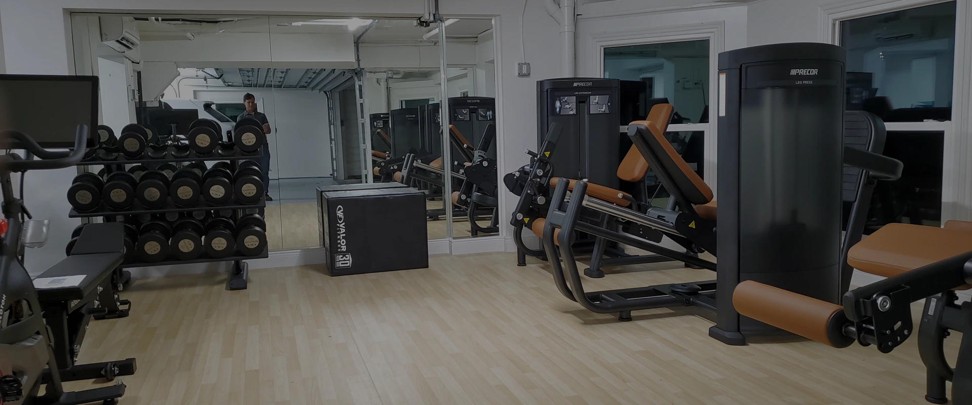 High-end residential garage gym in Clearwater, Florida featuring Precor strength equipment and a professionally designed layout